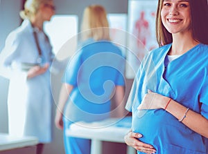 Beautiful smiling pregnant woman with the doctor at hospital