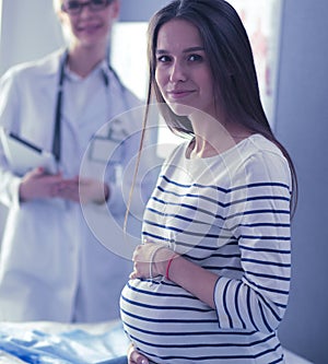 Beautiful smiling pregnant woman with the doctor at hospital