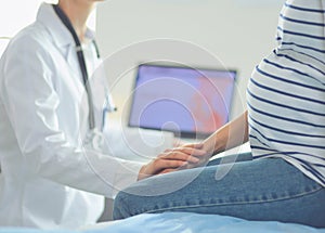 Beautiful smiling pregnant woman with the doctor at hospital