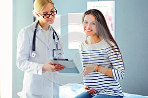 Beautiful smiling pregnant woman with the doctor at hospital