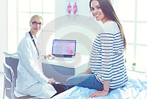 Beautiful smiling pregnant woman with the doctor at hospital