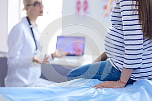 Beautiful smiling pregnant woman with the doctor at hospital