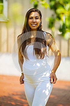 Beautiful smiling pregnant woman standing in her garden at home