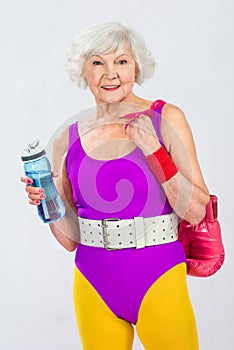 beautiful smiling senior sportswoman holding bottle of water