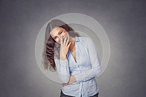 Beautiful smiling shy woman covering teeth with hand