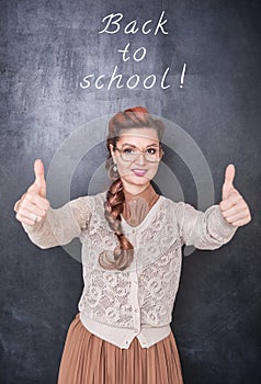 Beautiful smiling teacher showing thumbs up