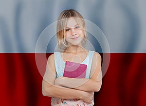 Beautiful smiling teen girl with book against flag of Poland background