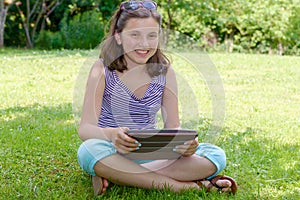 Beautiful smiling teenager with tablet pc, outdoors