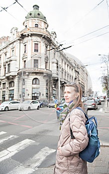 Beautiful smiling woman with bagpack and sunglasses standing on the street in the Belgrade city, Serbia photo