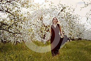 Beautiful smiling woman in the blooming apple garden.