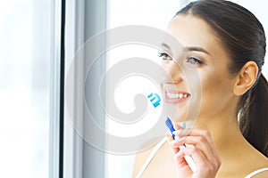 Beautiful Smiling Woman Brushing Healthy White Teeth With Brush.