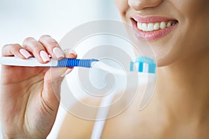 Beautiful Smiling Woman Brushing Healthy White Teeth With Brush.