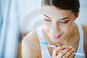 Beautiful Smiling Woman Brushing Healthy White Teeth With Brush.