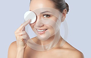 Beautiful smiling woman with clean skin holds a cotton pad. Women`s cosmetology, skin care