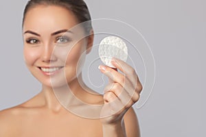 Beautiful smiling woman with clean skin holds a cotton pad. Women`s skin care