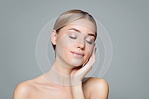 Beautiful smiling woman with clear skin relaxing. Facial treatment, haircare and cosmetology concept