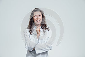 Beautiful smiling woman - the doctor looking at the camera half the turn. Happy and funny woman wearing a medical front