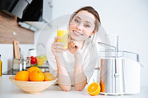Beautiful smiling woman drinking fresh orange juice