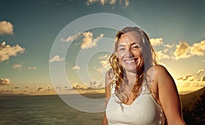 Beautiful smiling woman enjoying a tropical sunset