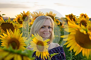 Beautiful smiling woman in the field with sunflowers