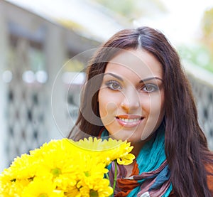 Beautiful smiling woman with flowers in autumn park