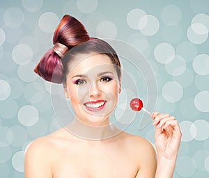 Beautiful smiling woman with a lollipop on bubble background