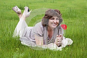 Beautiful smiling woman lying on the grass