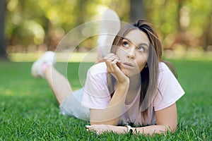 Beautiful smiling woman lying on a grass outdoor