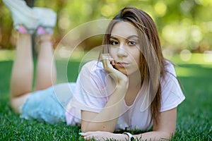 Beautiful smiling woman lying on a grass outdoor
