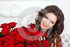 Beautiful smiling woman with makeup, red roses bouquet of flower