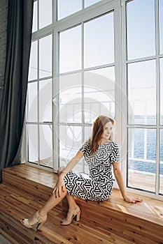 Beautiful smiling woman. Manicure nails. Makeup. Red long hair style. Elegant lady in black and white dress