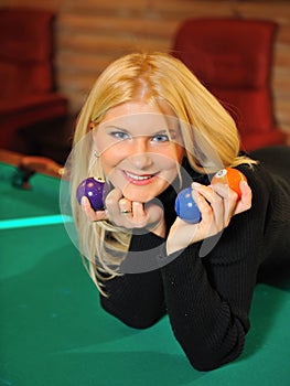 Beautiful smiling woman with many billiard balls