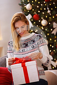 Beautiful woman opening Christmas gift