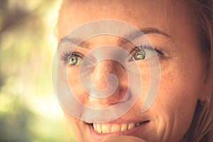 Beautiful smiling woman portrait in warm colors with sunlight on woman face with authentic smile and tan skin