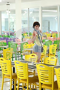 Beautiful smiling woman and posing for the camera among the multi-colored chairs.