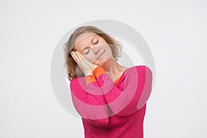 Beautiful smiling woman pretending that she is sleeping.