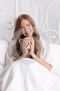 Beautiful smiling woman relaxing in the bed