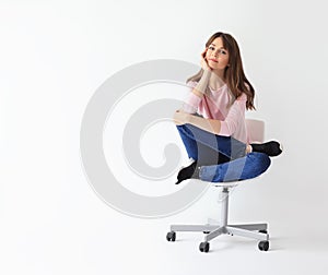 Beautiful smiling woman sitting on chair with copy space