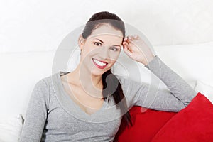 Beautiful smiling woman sitting on a sofa.