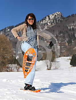 Beautiful smiling woman with snowshoes in winter photo