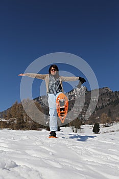 Beautiful smiling woman with snowshoes in winter photo
