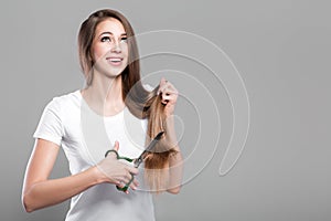 Woman with long hair holds scissors