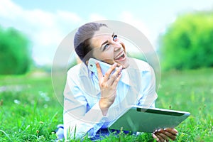 Beautiful smiling woman with tablet pc and talking on mobile phone