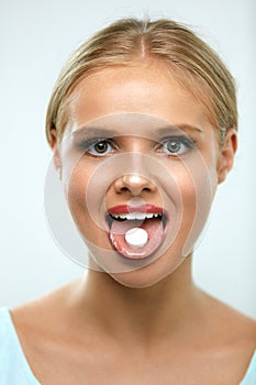 Beautiful Smiling Woman Taking Medicine, Holding Pill On Tongue