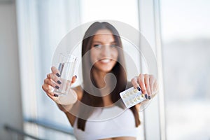 Beautiful Smiling Woman Taking Vitamin Pill. Dietary Supplement