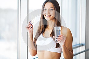 Beautiful Smiling Woman Taking Vitamin Pill. Dietary Supplement