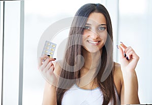 Beautiful Smiling Woman Taking Vitamin Pill. Dietary Supplement