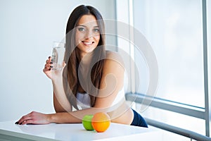 Beautiful Smiling Woman Taking Vitamin Pill. Dietary Supplement