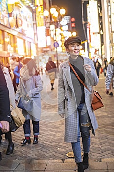 Beautiful smiling woman tourists traveling in walking at street shopping center Shibuya in Tokyo, Japan