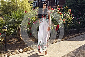 Beautiful smiling woman walking barefoot beside a villa